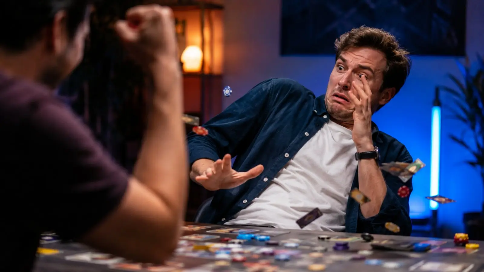 Portada del test de personalidad sobre cómo reaccionas al perder, con un hombre sorprendido ante una mesa de juego llena de fichas y cartas